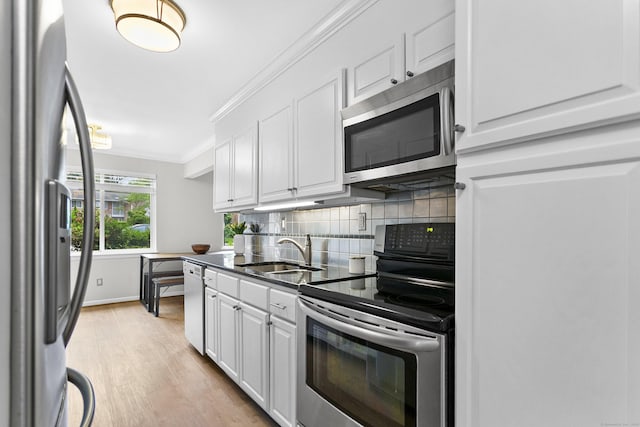 116 Southport Woods Dr, Fairfield, CT 06890 - kitchen with appliances with stainless steel finishes, a sink, white cabinets, backsplash, and crown molding