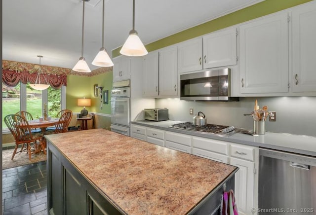 846 Arbutus St, Middletown, CT 06457 - kitchen with stainless steel appliances, a kitchen island, dark stone finish floors, and light countertops
