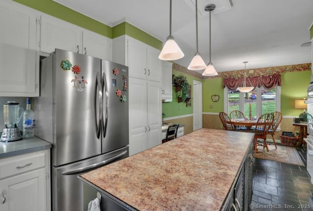 846 Arbutus St, Middletown, CT 06457 - kitchen with freestanding refrigerator, stone tile flooring, light countertops, white cabinets, and a wainscoted wall