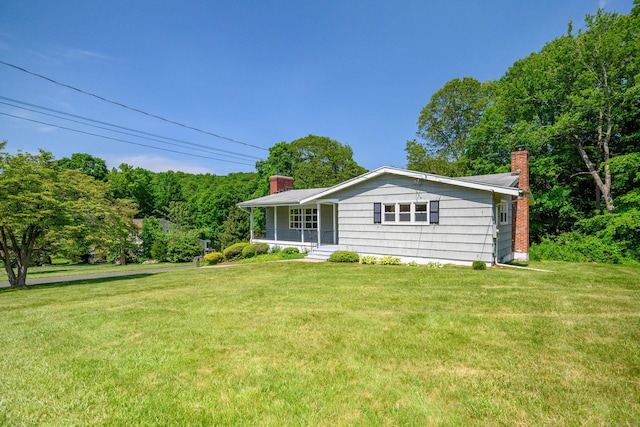 66 Hobby Dr, Ridgefield, CT 06877 - view of side of property with a chimney, a lawn, and covered porch