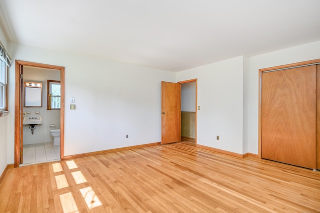 66 Hobby Dr, Ridgefield, CT 06877 - unfurnished bedroom featuring light wood-type flooring, baseboards, and connected bathroom