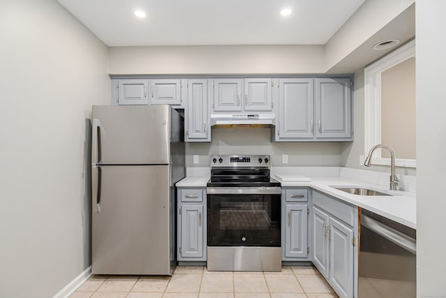 55 Mill Plain Rd Unit 34-14, Danbury, CT 06811 - kitchen featuring appliances with stainless steel finishes, under cabinet range hood, gray cabinets, a sink, and light countertops