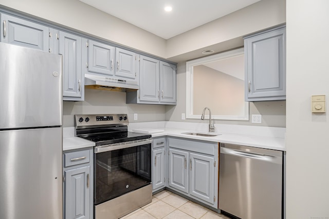 55 Mill Plain Rd Unit 34-14, Danbury, CT 06811 - kitchen with stainless steel appliances, a sink, gray cabinets, under cabinet range hood, and light countertops