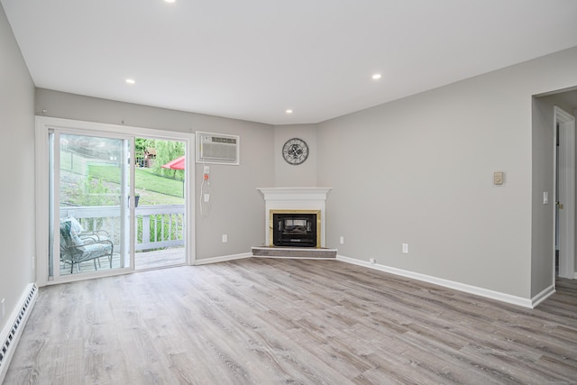 55 Mill Plain Rd Unit 34-14, Danbury, CT 06811 - unfurnished living room with a baseboard heating unit, a wall mounted air conditioner, wood finished floors, recessed lighting, and baseboards