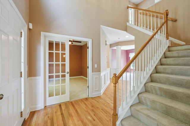 67 Bartman Rd, Haddam, CT 06441 - foyer featuring wood finished floors, ceiling fan, a high ceiling, stairs, and a wainscoted wall