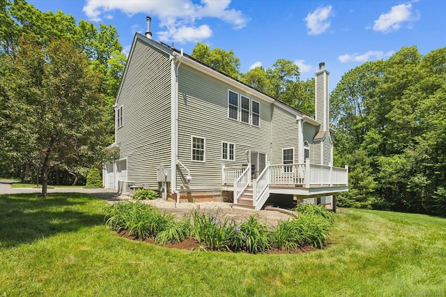 67 Bartman Rd, Haddam, CT 06441 - rear view of house with a chimney, a deck, a lawn, and a garage