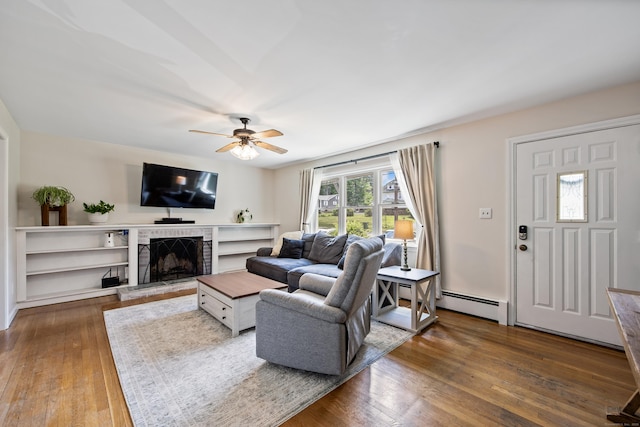 881 Pine St, Bristol, CT 06010 - living area featuring a ceiling fan, hardwood / wood-style floors, a brick fireplace, and a baseboard radiator