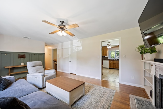 881 Pine St, Bristol, CT 06010 - living area with ceiling fan, wood finished floors, and a fireplace with flush hearth