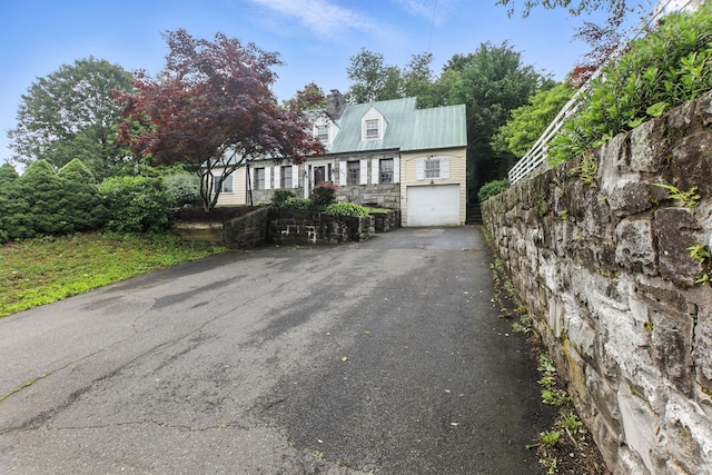 567 Bunker Hill Ave, Waterbury, CT 06708 - cape cod house featuring asphalt driveway, an attached garage, stone siding, and a chimney