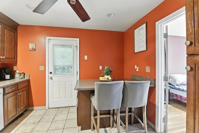 567 Bunker Hill Ave, Waterbury, CT 06708 - kitchen featuring brown cabinetry, a breakfast bar area, a peninsula, and a ceiling fan