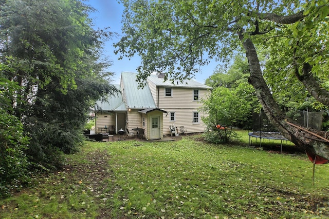 567 Bunker Hill Ave, Waterbury, CT 06708 - back of property with a trampoline, a metal roof, and a lawn