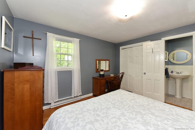 10 Brewer Rd, East Hampton, CT 06424 - bedroom with baseboard heating, a closet, a sink, wood finished floors, and ensuite bath
