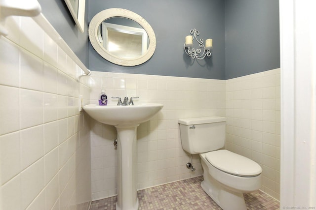 10 Brewer Rd, East Hampton, CT 06424 - bathroom with toilet, tile walls, a wainscoted wall, tile patterned flooring, and a sink