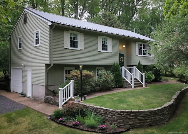 10 Brewer Rd, East Hampton, CT 06424 - back of property with an attached garage, metal roof, and a yard