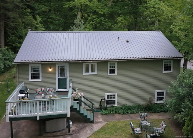 10 Brewer Rd, East Hampton, CT 06424 - back of property featuring metal roof, a forest view, and a wooden deck
