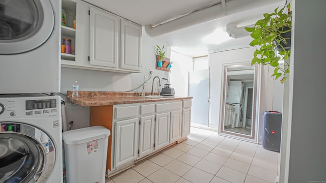 1149 Central Ave, Bridgeport, CT 06607 - laundry area featuring stacked washer / drying machine, cabinet space, and light tile patterned floors