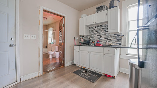 1149 Central Ave, Bridgeport, CT 06607 - kitchen featuring white cabinets, backsplash, and plenty of natural light