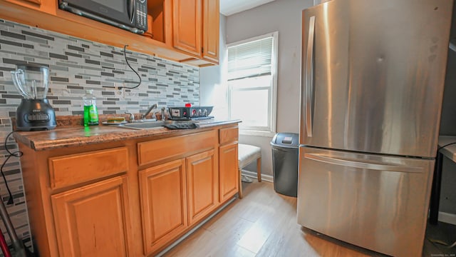 1149 Central Ave, Bridgeport, CT 06607 - kitchen with freestanding refrigerator, black microwave, a sink, light wood-type flooring, and decorative backsplash