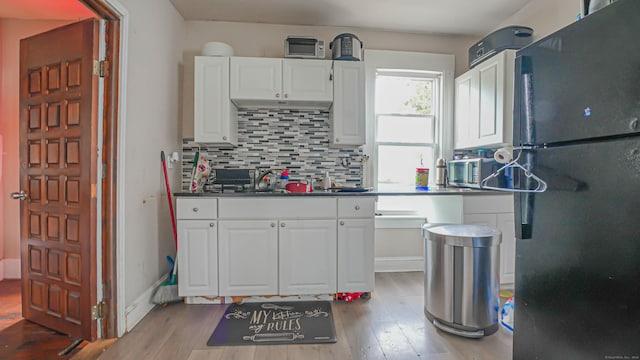 1149 Central Ave, Bridgeport, CT 06607 - kitchen featuring freestanding refrigerator, wood finished floors, white cabinetry, decorative backsplash, and dark countertops
