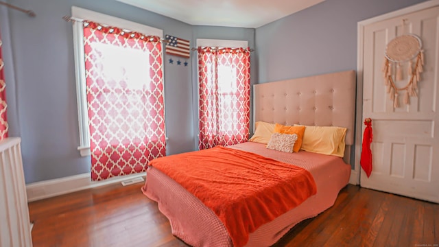 1149 Central Ave, Bridgeport, CT 06607 - bedroom with wood finished floors, multiple windows, baseboards, and radiator