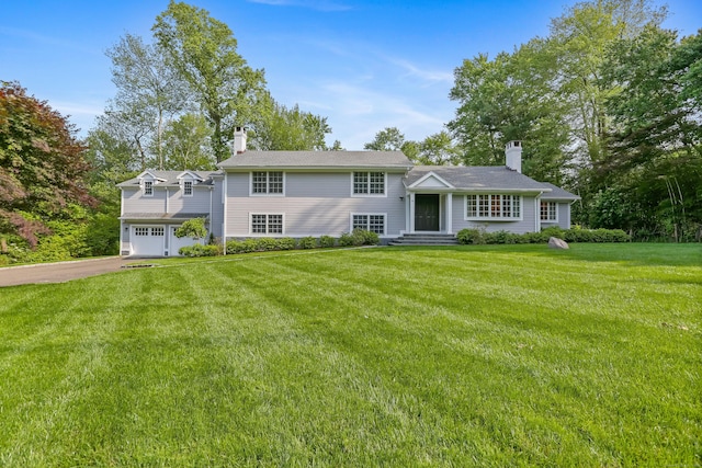 25 Conrad Rd, New Canaan, CT 06840 - view of front of home with a chimney, a garage, driveway, and a front lawn