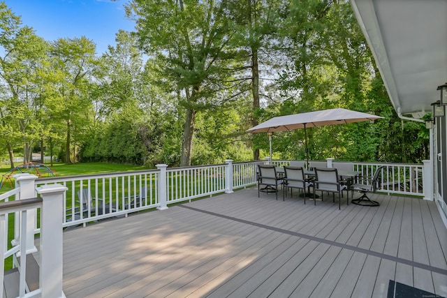 25 Conrad Rd, New Canaan, CT 06840 - wooden deck with outdoor dining space, view of wooded area, and a lawn