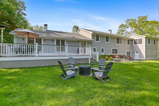 25 Conrad Rd, New Canaan, CT 06840 - rear view of property featuring a chimney, a fire pit, a lawn, and a deck