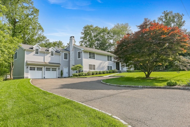 25 Conrad Rd, New Canaan, CT 06840 - view of front facade featuring driveway, a chimney, a front yard, and an attached garage