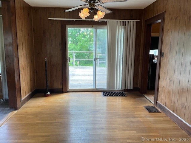 79 Van St, Stratford, CT 06614 - empty room with wooden walls, light wood-type flooring, a ceiling fan, and baseboards