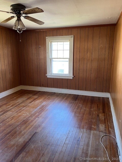 79 Van St, Stratford, CT 06614 - spare room featuring dark wood finished floors, a ceiling fan, and wooden walls