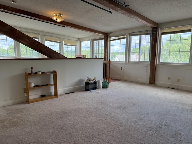45 Main St Apt 401, Plainfield, CT 06374 - carpeted spare room featuring a textured ceiling, healthy amount of natural light, beamed ceiling, and baseboards