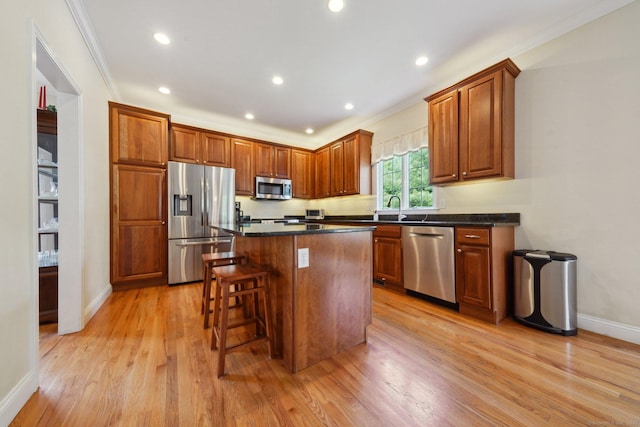 2 Tobins Ct, Danbury, CT 06810 - kitchen with stainless steel appliances, light wood finished floors, dark countertops, a center island, and crown molding