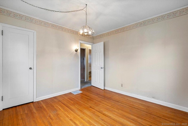 23 Salem Rd, East Hartford, CT 06118 - spare room with light wood-style floors, baseboards, crown molding, and a chandelier