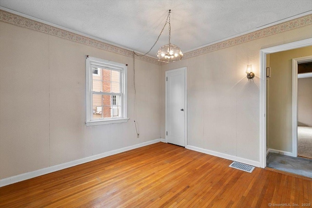 23 Salem Rd, East Hartford, CT 06118 - empty room featuring light wood-type flooring, a chandelier, baseboards, a textured ceiling, and crown molding