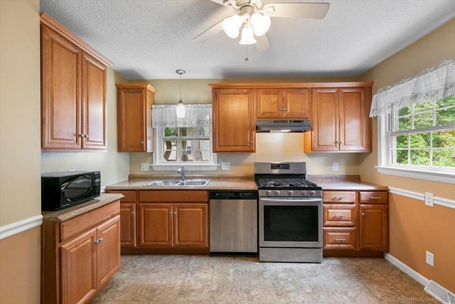 23 Salem Rd, East Hartford, CT 06118 - kitchen featuring appliances with stainless steel finishes, under cabinet range hood, a sink, brown cabinets, and light countertops