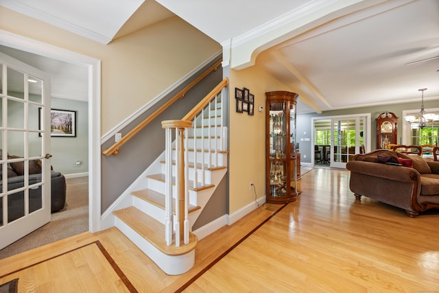 155 Garrigus Ct, Wolcott, CT 06716 - stairway with wood finished floors, a chandelier, ornamental molding, and baseboards