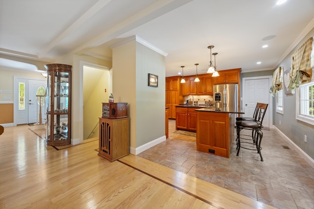 155 Garrigus Ct, Wolcott, CT 06716 - kitchen featuring stainless steel refrigerator with ice dispenser, baseboards, dark countertops, a breakfast bar, and ornamental molding