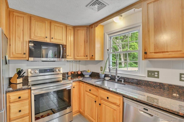 41 Blueberry Cir, Ellington, CT 06029 - kitchen featuring stainless steel appliances, a sink, decorative backsplash, dark stone counters, and a textured ceiling
