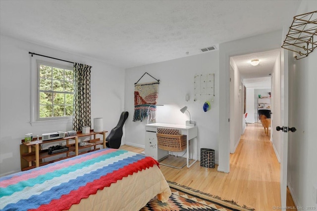 41 Blueberry Cir, Ellington, CT 06029 - bedroom with light wood finished floors, a textured ceiling, and baseboards