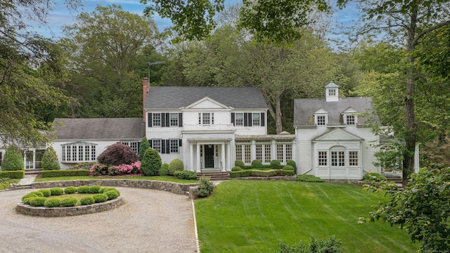 130 Easton Rd, Westport, CT 06880 - view of front facade with a front lawn, a chimney, and curved driveway