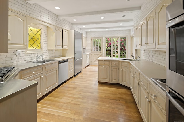 130 Easton Rd, Westport, CT 06880 - kitchen featuring appliances with stainless steel finishes, a sink, light wood finished floors, backsplash, and light countertops