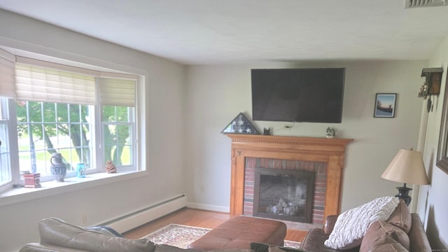 67 Geer St, Cromwell, CT 06416 - living room featuring a brick fireplace, wood finished floors, baseboard heating, and baseboards