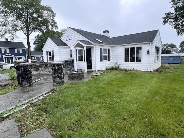39 Commodore Pl, Milford, CT 06460 - rear view of property featuring a lawn, a chimney, a shingled roof, and a patio