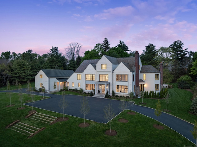 7 Dairy Rd, Greenwich, CT 06830 - view of front of property featuring curved driveway, a chimney, a lawn, and view of wooded area