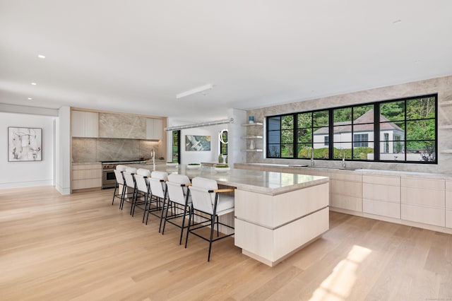 7 Dairy Rd, Greenwich, CT 06830 - kitchen featuring modern cabinets, light wood-type flooring, tasteful backsplash, a spacious island, and recessed lighting