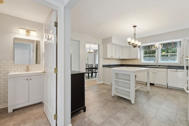 21 Dilaj Dr, Columbia, CT 06237 - kitchen featuring a chandelier, white dishwasher, tasteful backsplash, a sink, and white cabinetry