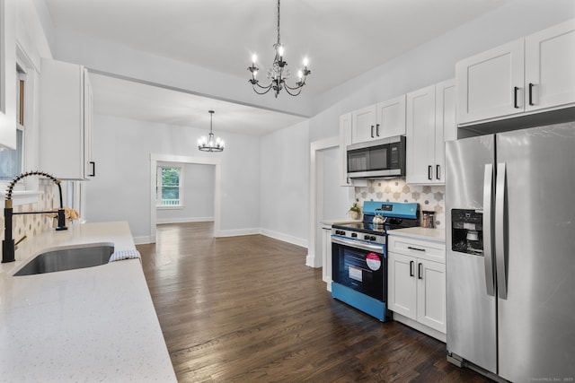 452 New Haven Ave, Derby, CT 06418 - kitchen featuring appliances with stainless steel finishes, a chandelier, a sink, backsplash, and dark wood finished floors