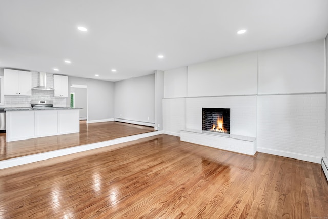 325 River Rd, Hamden, CT 06518 - unfurnished living room with a baseboard radiator, a fireplace, wood finished floors, recessed lighting, and baseboards