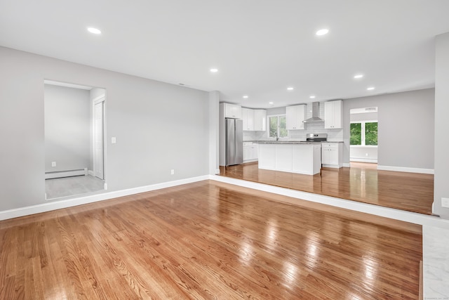 325 River Rd, Hamden, CT 06518 - unfurnished living room with baseboard heating, recessed lighting, baseboards, a sink, and light wood-type flooring