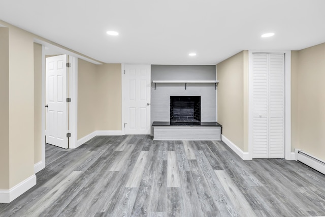 325 River Rd, Hamden, CT 06518 - unfurnished living room with wood finished floors, baseboards, a brick fireplace, recessed lighting, and a baseboard radiator